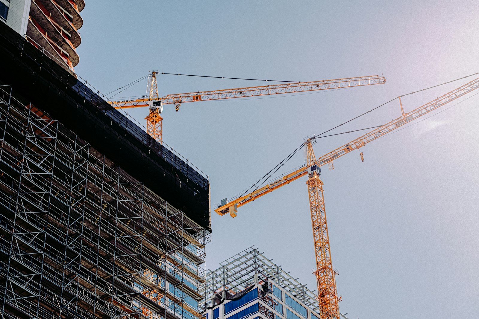 Tower cranes over an industrial construction site at dusk