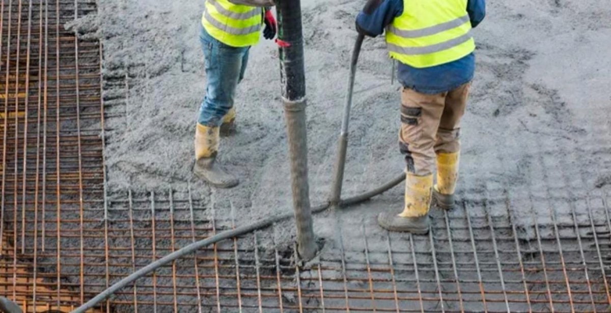 Crew placing concrete over reinforcement mesh during a foundation pour